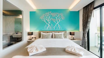 A modern hotel room with a large bed, a decorative wall art of trees, and a view of the outdoors.