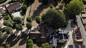 An aerial view of a residential area with a swimming pool, trees, and houses. - Au Cocon de Sologne (Soings-en-Sologne)