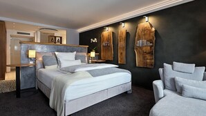 A modern bedroom with a large bed, bedside tables, a desk, and a chair. - Höll am Main (Ruesselsheim)