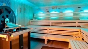 A sauna with wooden benches and a massage table. - Höll am Main (Ruesselsheim)