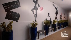 A hotel corridor with modern decor, including wall art and potted plants. - Hotel Turista Canlubang (Calamba)