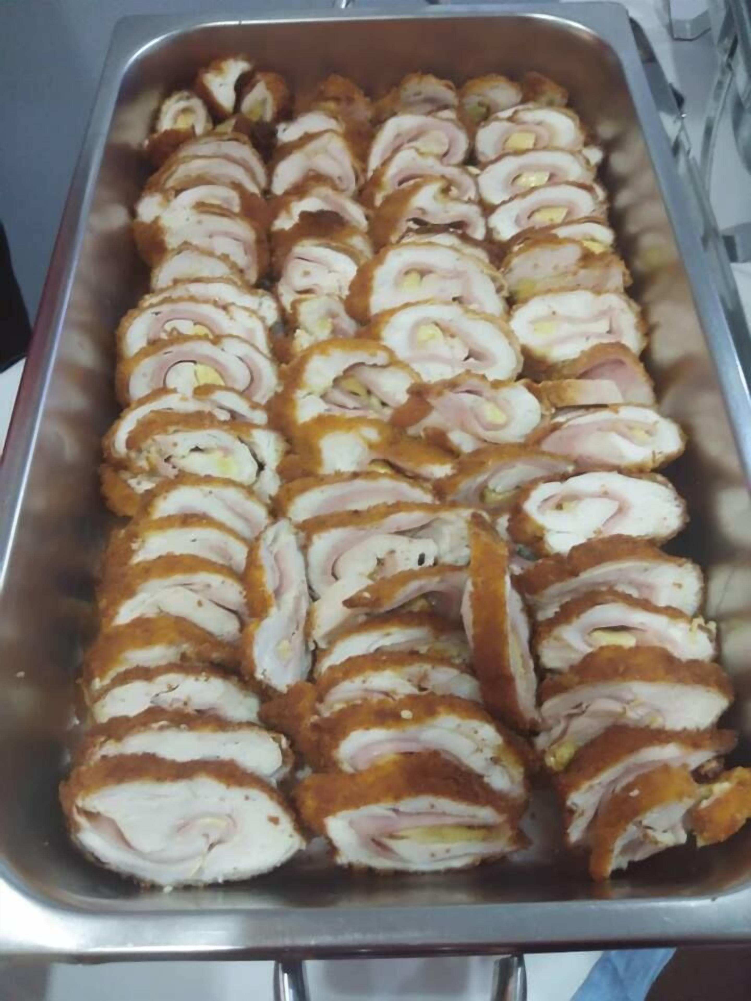 Uma travessa com rolinhos de carne dispostos em fileiras.