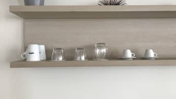 Una estantería con diferentes vasos y una planta en maceta.