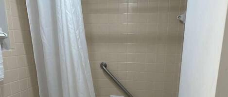 A bathroom with a toilet, a bathtub, and a shower curtain.