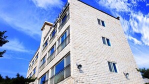 A multi-story building with a brick facade and multiple windows. - Yeongheungdo Seayard Pension (Incheon)