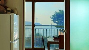 A room with a sliding glass door leading to a balcony. - Yeongheungdo Seayard Pension (Incheon)