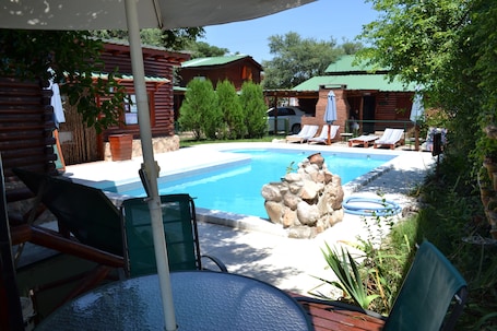 Una piscina al aire libre, sillones reclinables de piscina