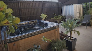 A hot tub surrounded by potted plants and a wooden fence. - Mount Gravatt Guesthouse (Mount Gravatt East)