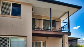 A modern two-story house with a balcony, large windows, and potted plants. - Mount Gravatt Guesthouse (Mount Gravatt East)