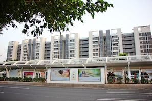 A modern multi-story building with a covered pedestrian walkway. - Iway Aparment Hotel Pazhou Branch (Guangzhou)
