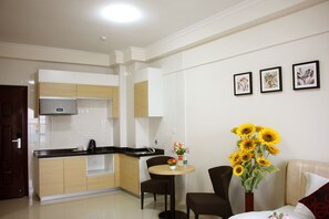 Una cocina moderna con comedor, un jarrón de girasoles y tres impresiones botánicas enmarcadas en la pared.