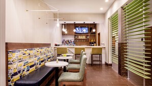 A modern bar area with seating, a television, and a bar counter.