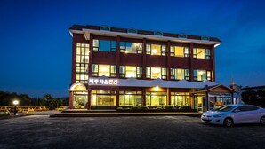 Un edificio de varios pisos con amplios ventanales y un área de entrada cubierta.