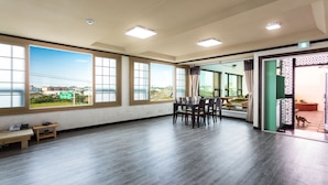 Una habitación amplia con ventanas grandes, un comedor y vistas al exterior.