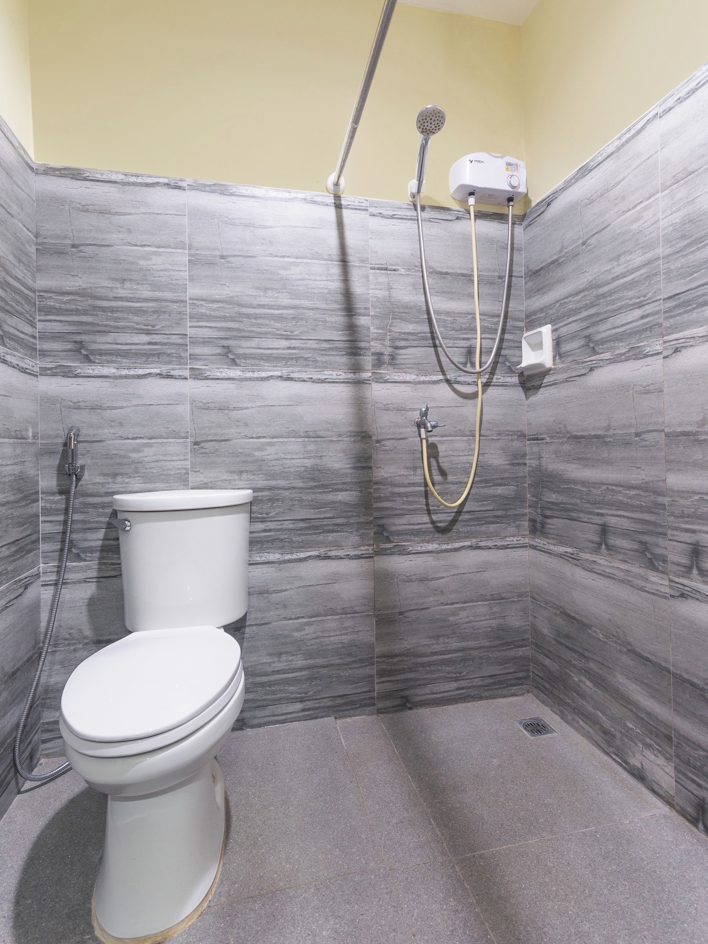 A bathroom with a toilet, a shower, and a bidet.
