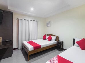 A hotel room with a bed, a desk, and a TV. - Vaccinated Staff - OYO 567 Blue Horizon Hostel (Dumaguete)