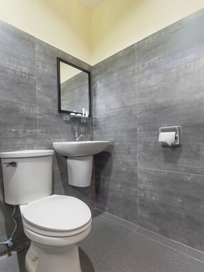 A bathroom with a toilet, sink, and mirror. - Vaccinated Staff - OYO 567 Blue Horizon Hostel (Dumaguete)