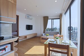 Appartement Deluxe, 1 grand lit, vue sur le lac, au bord du lac | Aire de séjour | Téléviseur ACL de 42 po avec télévision par câble, téléviseur
