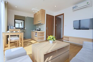 Una sala de estar moderna con una mesa de centro de madera, un sofá y un televisor montado en la pared.