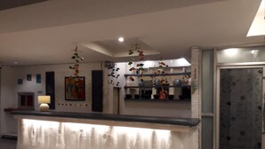 A modern reception area with a counter, decorative hanging elements, and a glass door. - Sea Turtle Hostel - Adults Only (Ko Chang)
