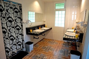 A bathroom with two sinks, a mirror, and patterned tiles.