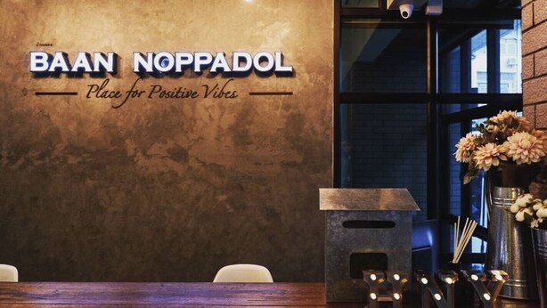 L’intérieur d’un restaurant, avec une enseigne indiquant : « BAAN NOPPADOL, un lieu où l’on se sent bien ».