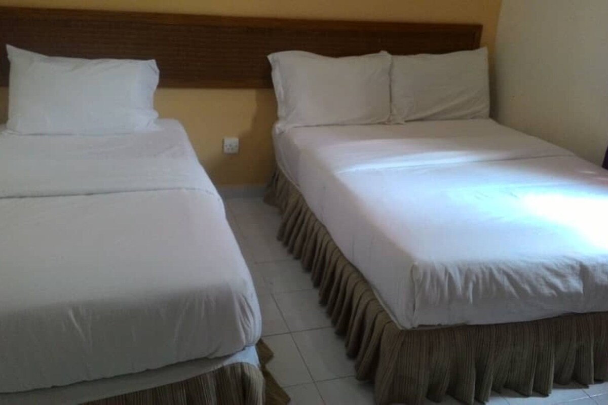 A double bed with a wooden headboard and a matching bed skirt.