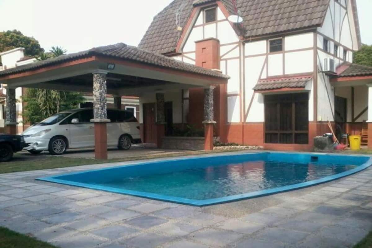 A house with a swimming pool, a covered patio, and a car parked outside.