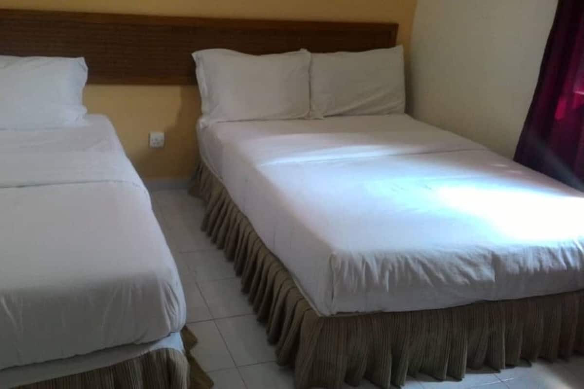 A double bed with a wooden headboard and a matching bed skirt.