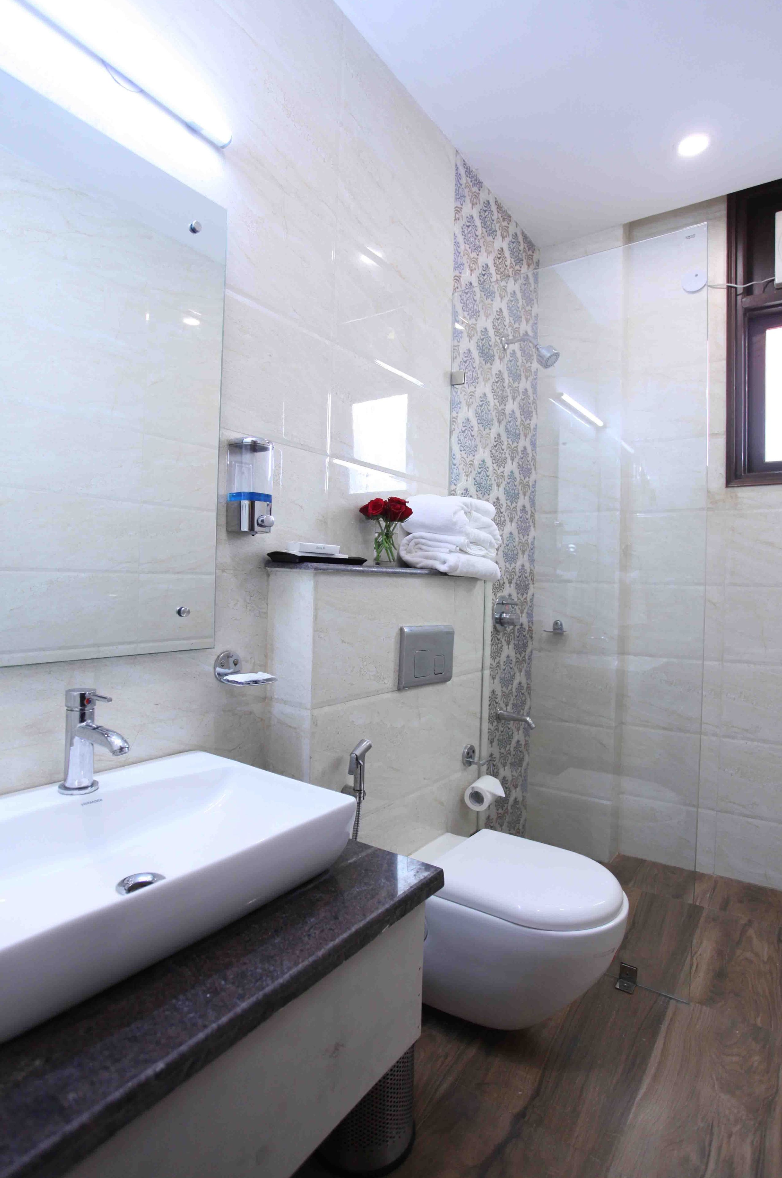 A modern bathroom with a white sink, a toilet, and a shower area.