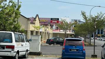 A street view with parked cars, a building with signage for 'Visions' and 'Pyrex', and a clear sky.