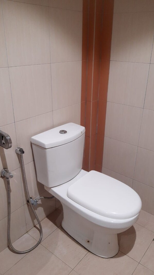 A standard bathroom with a toilet, a shower, and a sink. - Baron Waterfront Hotel (Langkawi)