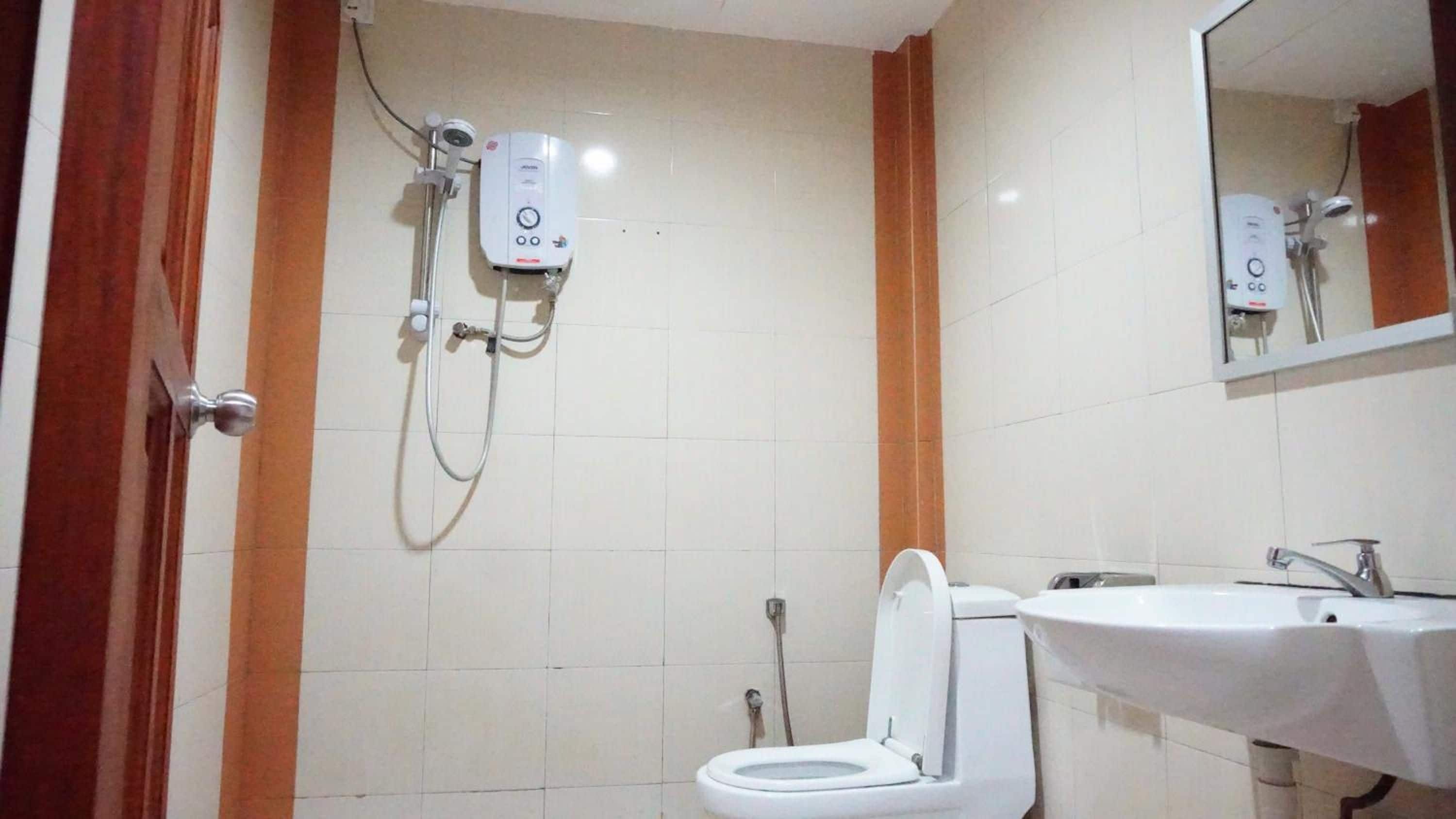 A bathroom with a toilet, a sink, and a shower unit.