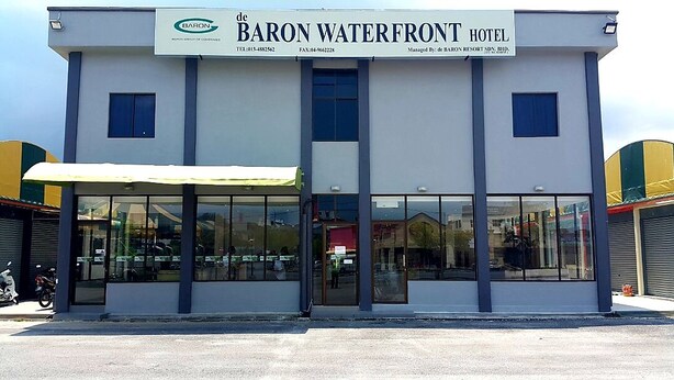 El exterior del Hotel Baron Waterfront con un amplio toldo sobre la entrada.