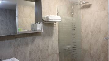 Un bagno moderno con box doccia in vetro, lavabo incassato e specchio sopra il lavabo.
