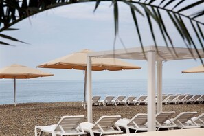 En la playa, camastros, sombrillas y toallas de playa 