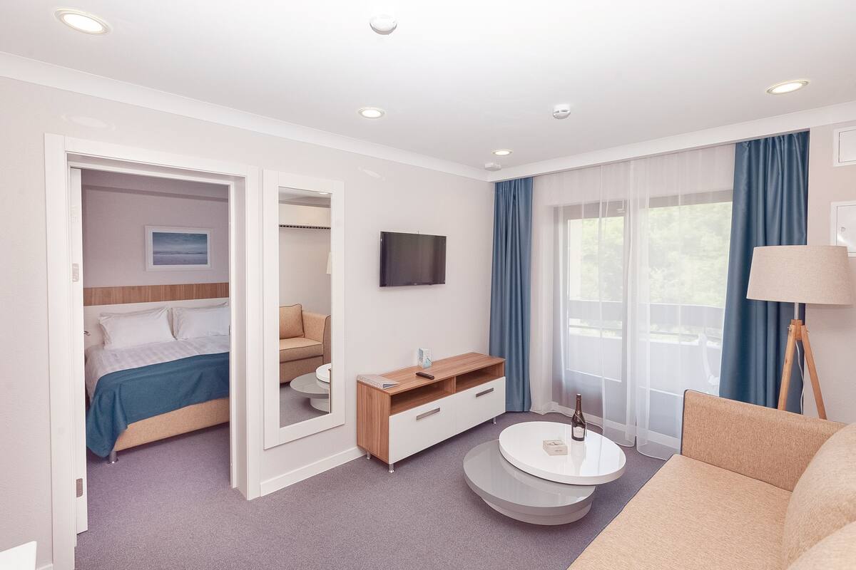 Habitación de lujo | Área de sala de estar | Televisión, futbolito y tenis de mesa