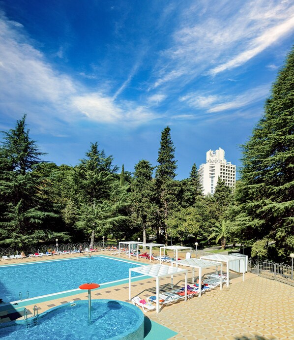 Alberca al aire libre, sombrillas en la alberca y camastros 