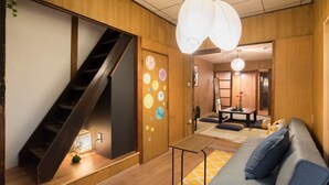 A modern interior with a wooden staircase, a sofa, and a dining area. - Ikenoya (Kyoto)