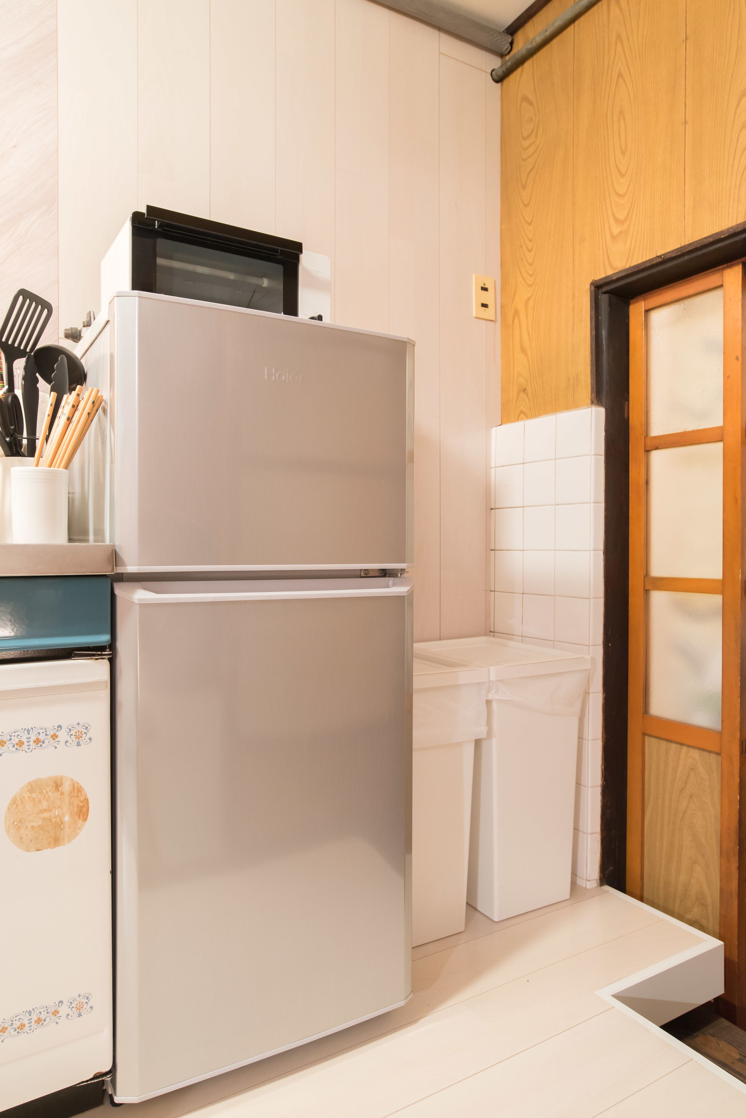 A kitchen with a white refrigerator, a microwave, and a sink.