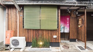 A traditional Japanese building with a wooden exterior, a green shoji screen, and a sign indicating it is a guest house. - Ikenoya (Kyoto)