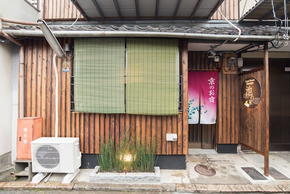 A traditional Japanese building with a wooden exterior, a green shoji screen, and a sign indicating it is a guest house. - Ikenoya (Kyoto)