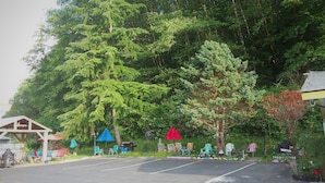 A parking area with a row of trees and a gazebo. - Shiny Motel (Hoquiam)