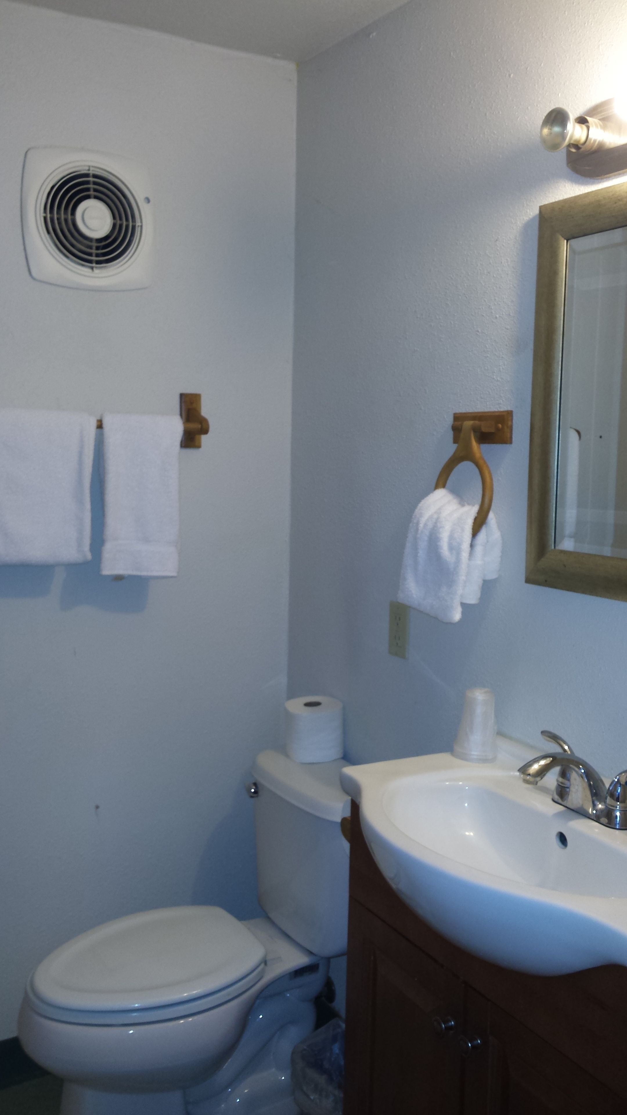 Ein Badezimmer mit Toilette, Waschbecken und Handtuchhalter.
