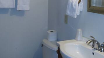 Ein Badezimmer mit Toilette, Waschbecken und Handtuchhalter.