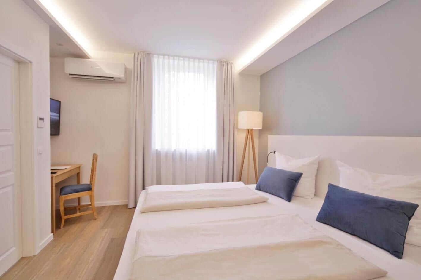 Una habitación de hotel con una cama grande, un escritorio y una silla.