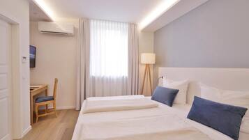 Una habitación de hotel con una cama grande, un escritorio y una silla.