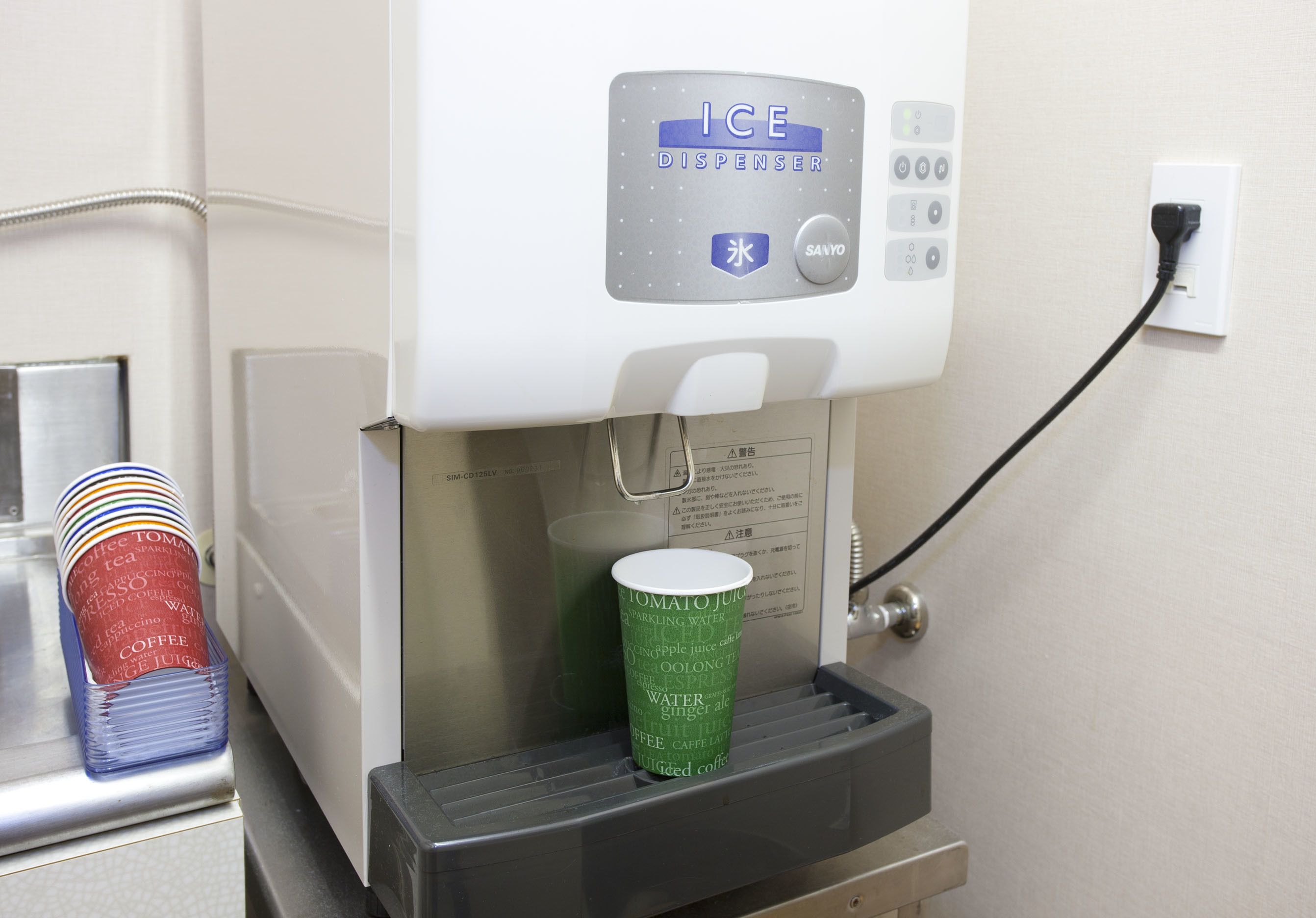Dispensador de hielo con panel de control y portavasos.