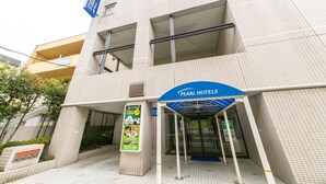 Entrada de hotel con un letrero que dice "Pearl Hotels".