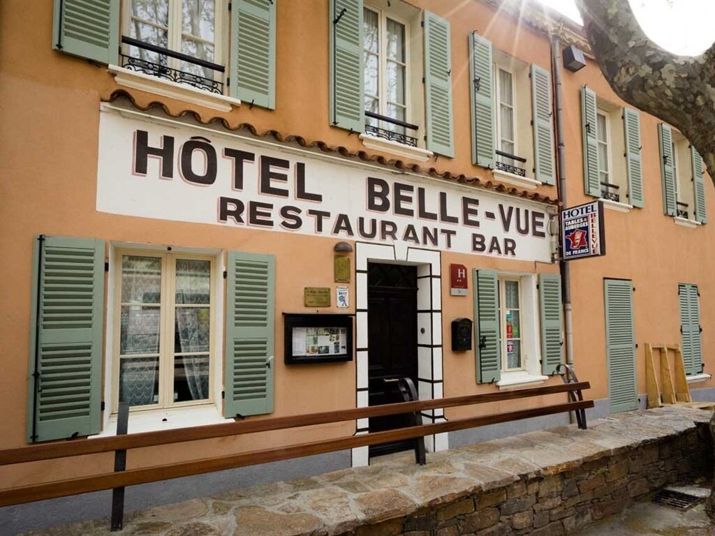 Un edificio con un letrero que dice "HOTEL BELLE-VUE RESTAURANT BAR".